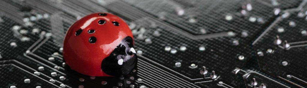 Computer bug, failure or error of software and hardware concept, miniature red ladybug on black computer motherboard PCB with soldering, programmer can debug to search for cause of error. (Computer bug, failure or error of software and hardware concep